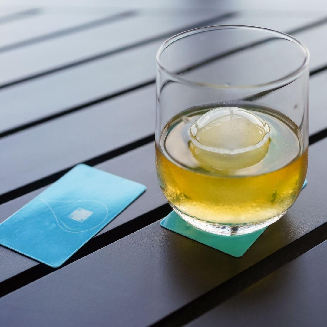 Glass of whiskey placed on a BOCE card coaster
